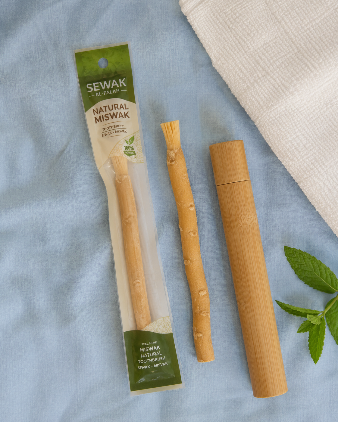 Ancient Miswak Toothbrush 1pc - flatlay with packaging, bare stick, and bamboo travel case